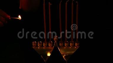 那女人用手把蜡烛插在烛台上，准备光明节。 静态摄像机