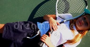 可爱的女学生在网球场放松的肖像