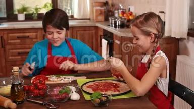 孩子们在家里做披萨，传播和品尝酱汁