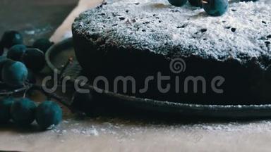 巧克力蛋糕，巧克力蛋糕，巧克力蛋糕，慷慨地覆盖着糖粉，时髦地躺在蓝色浆果旁边。