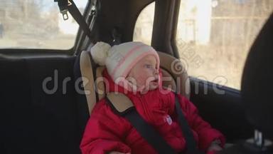 一个一岁的小孩子坐在汽车座椅上看着窗外
