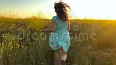 美丽的女孩在日落的天空上<strong>奔跑</strong>在绿色的麦田上。 <strong>自由</strong>概念。 日落时的麦田。 慢动作