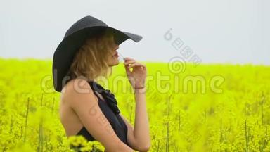 一个女孩在一个阳光明媚的下午在油菜花田里