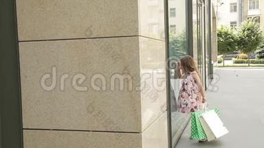 小女孩看着购物中心附近的窗户