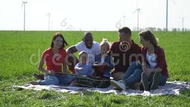 一群带着孩子的人在野餐时享受着美妙的天气