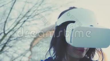 年轻女子戴着虚拟现实眼镜、耳机、玩虚拟游戏和在户外<strong>观看视频</strong>。