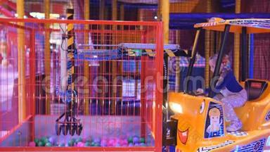 吸引孩子。 小女孩在商场中心的游戏公园里玩儿童建筑起重机。