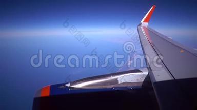 发动机机翼飞机天空概念。 从窗口飞机上看到飞机的机翼、天空和云日落的美丽。