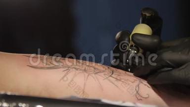 特写纹身艺术家演示了用油漆纹身的过程。 无菌手套。 纹身大师