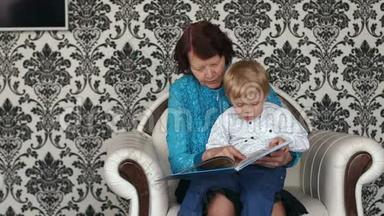 奶奶和小男孩拿着<strong>书</strong>坐在沙发上。
