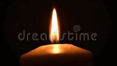 <strong>只有</strong>一支蜡烛燃烧，在黑色背景上被隔离。 仍然是烛光。
