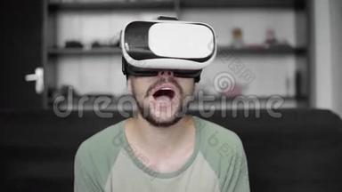 年轻的大胡子嬉皮士开始使用他的VR耳机显示器与耳机虚拟现实游戏或观看