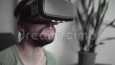 年轻留胡子的嬉皮士使用他的VR耳机显示器<strong>观看</strong>360<strong>视频</strong>，而坐在沙发上和吃