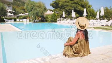 在豪华酒店度假胜地的泳池边放松的女士享受完美的海滩度假
