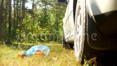 一个蓝色的袋子里装着塑料瓶的垃圾，躺在汽车附近的<strong>大自然</strong>上，塑料垃圾污染了<strong>大自然</strong>
