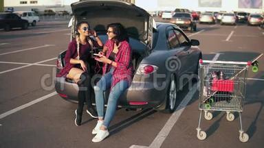 两个戴着太阳镜的年轻美女坐在敞篷车厢里听着车厢里的音乐