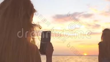 海滩上的一个年轻女孩在电话里拍照。