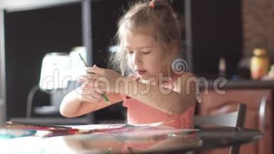 六岁的孩子坐在一张桌子旁画房子。 <strong>清晨阳光下</strong>的小女孩