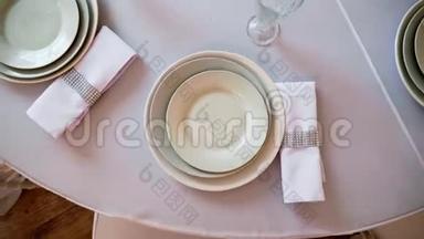 带有白色桌布的圆桌，餐盘，酒杯和餐巾纸