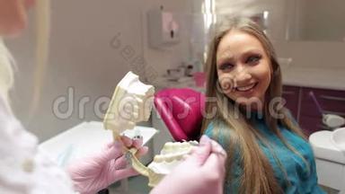 医生向她的病人解释了塑料<strong>牙齿</strong>模型的<strong>问题</strong>。