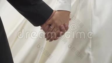 新婚夫妇的特写镜头是在<strong>走路</strong>时轻轻地握住双手。 没有脸。