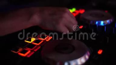夜总会的混合控制台。 DJ控制器。 `DJ的手后面的DJ控制器特写..