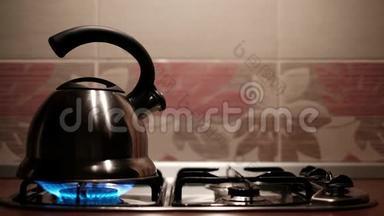 金属水壶用喷口喷出的蒸汽沸腾。 为茶做热水的男人