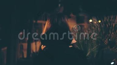 迷人的黑发女人深夜散步的背景。迷人的女孩独自穿过市中心。