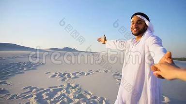 年轻的阿拉伯导游`女孩的手和进行交谈，在温暖的夏天晚上漫步广阔的沙漠。