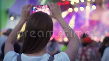 露天摇滚音乐会的人群<strong>聚会</strong>。 女人站着，手里拿着智能手机拍摄视频