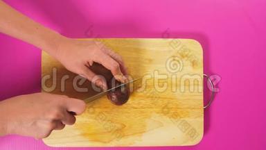 俯视图，女手用刀<strong>切水果</strong>在木板上，马拉库亚.. 天然健康食品的概念..