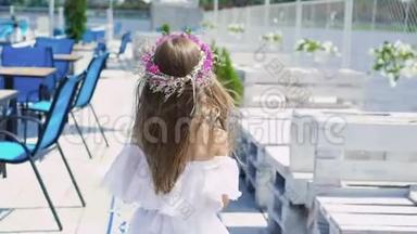 小女孩走在酒吧湾上，带着花旋转。 慢慢地