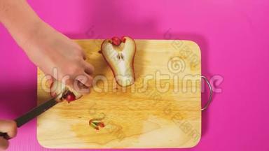 俯视图，雌手在木板上用刀切水果，玫瑰苹果，春浦.. 自然健康的概念