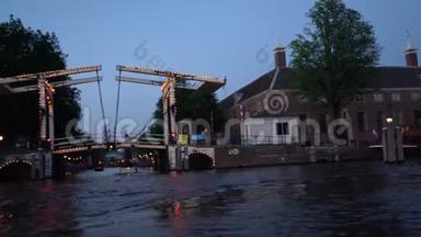 阿姆斯特丹的<strong>夜景</strong>。 由<strong>照明</strong>、建筑和路灯装饰的运河、经过桥下的船只。