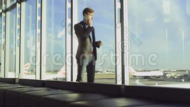 年轻的商人正在机场<strong>空无</strong>一人的候机大厅里谈论他的智能手机