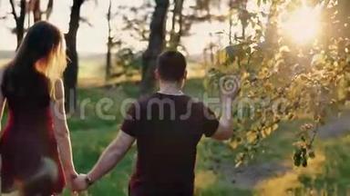 日落时分，一对幸福的夫妇在森林里牵手散步。 慢莫，稳定射击