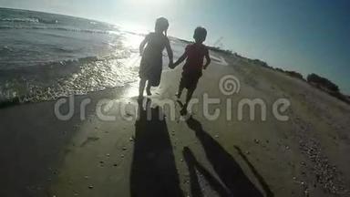 快乐的女孩和男孩赤脚在沙滩上奔跑