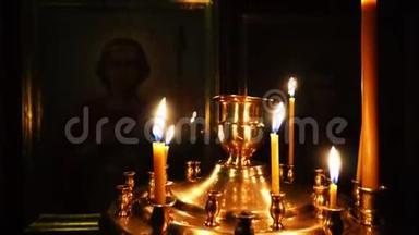 在黑暗的教堂里用燃烧的蜡烛进行视频特写。 相机锅。