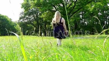 穿着裙子的小女孩走在草地上的草地上
