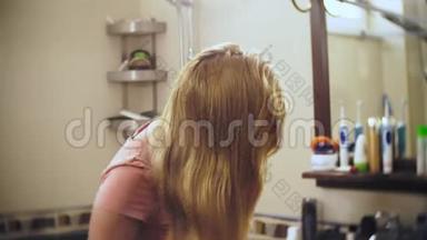 女人<strong>掉头发</strong>，一个金发的女人在镜子前的浴室里梳着长发。 <strong>头发</strong>留在上面