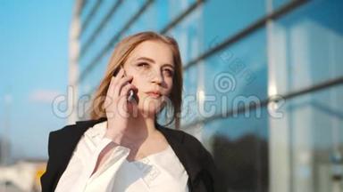 华丽时尚的年轻女子穿着优雅的服装穿过机场航站楼，在电话中交谈。 <strong>天气晴朗</strong>