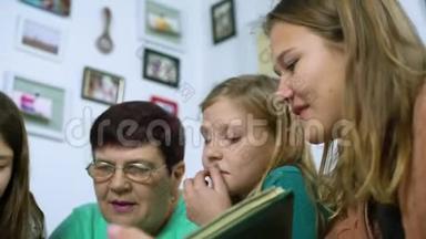 祖母和四个孙女在家看旧相册的特写