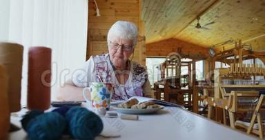 坐在桌子上计算4k的老妇人