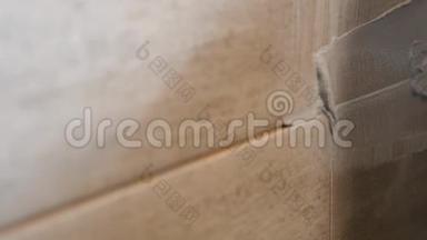 男人`手把米黄色瓷砖的接缝放在墙上。 关门