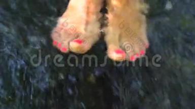 一个赤脚女孩，她的脚踩着粉红色的踏板，在一条湍急的小溪里，在水中嬉戏
