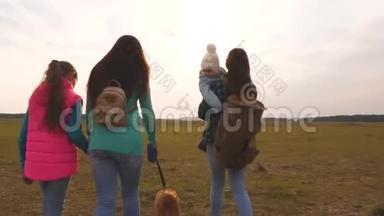 妈妈，小孩女儿和宠物游客.. 一家人和狗在平原上旅行。 紧密结合的团队合作