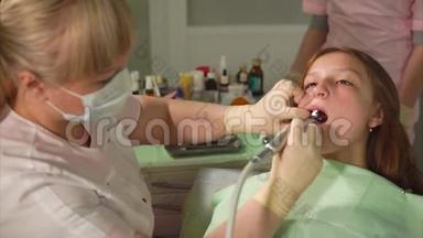 一个戴乳胶手套的牙医用金属工具在一个十几岁的孩子身上磨牙