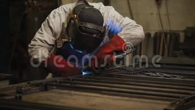 工厂工人正在工厂的一个车间里焊接金属