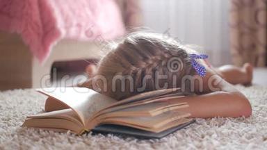 画像悲伤的女学生不想读书读书。一个可爱的金发女孩睡在书上，她累了