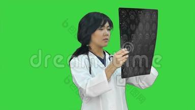 亚洲女医生使用<strong>数码</strong>平板电脑，在绿色<strong>屏</strong>幕上微笑，Chroma键
